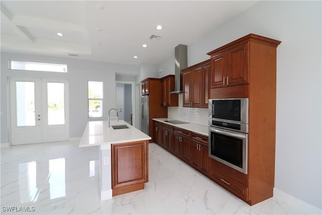 kitchen featuring stainless steel fridge, decorative backsplash, a kitchen island with sink, black electric cooktop, and wall chimney exhaust hood