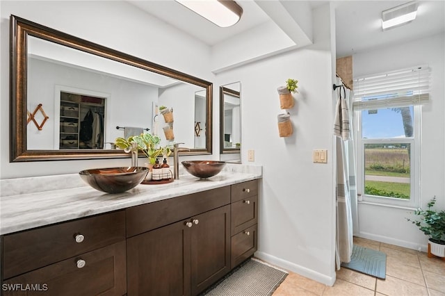 bathroom featuring tile patterned floors, visible vents, a sink, and double vanity