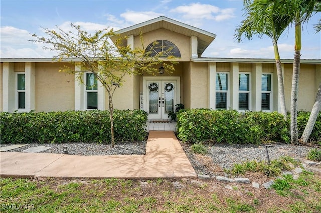 doorway to property featuring stucco siding and french doors