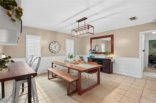 dining area with wainscoting, visible vents, and light tile patterned floors