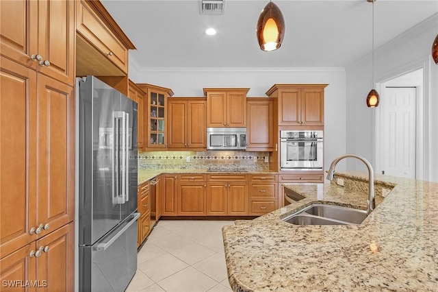 kitchen with visible vents, brown cabinetry, appliances with stainless steel finishes, crown molding, and a sink