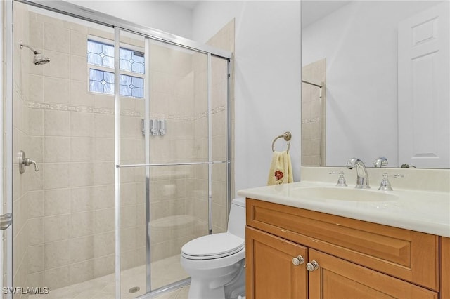 full bath featuring toilet, a stall shower, and vanity