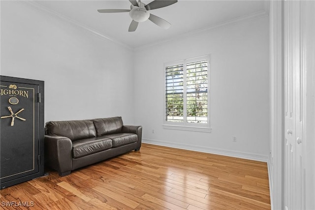 sitting room with light wood finished floors, baseboards, ornamental molding, and ceiling fan