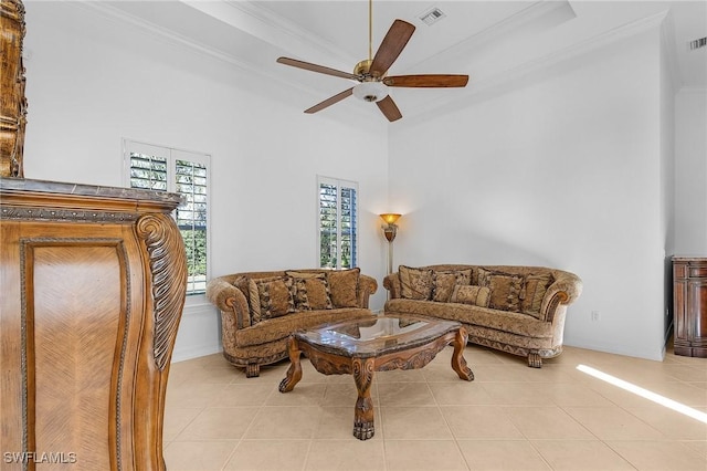 living area featuring tile patterned flooring, visible vents, ceiling fan, and ornamental molding