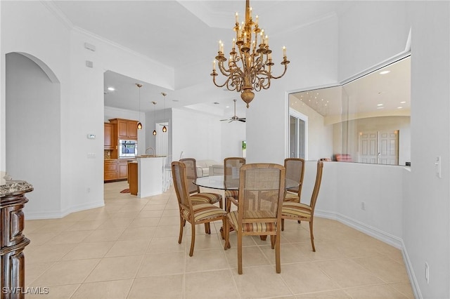 dining room with light tile patterned floors, baseboards, arched walkways, and crown molding