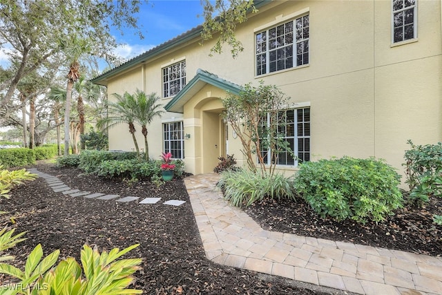 doorway to property featuring stucco siding