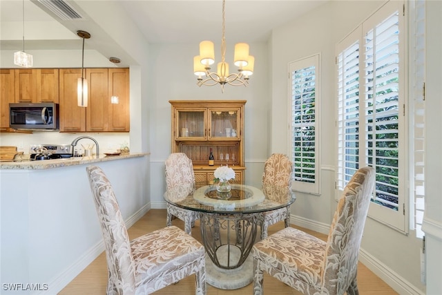 dining room with a wealth of natural light, baseboards, and a chandelier