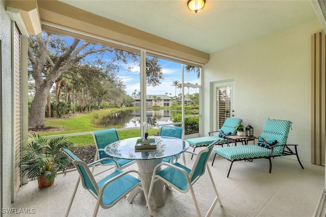 sunroom featuring a water view