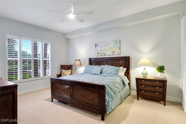 bedroom featuring light colored carpet, a ceiling fan, and baseboards