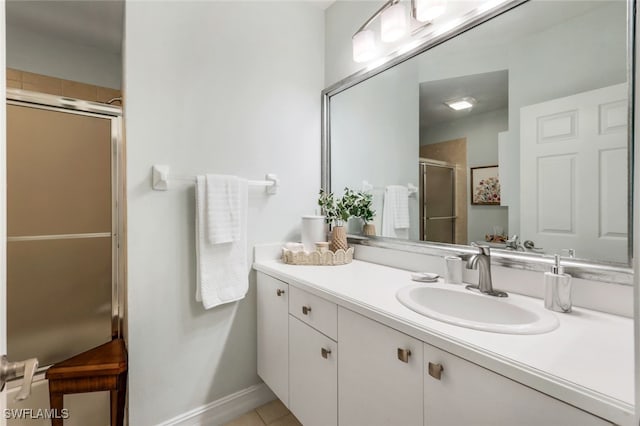 bathroom featuring baseboards, a stall shower, vanity, and tile patterned flooring