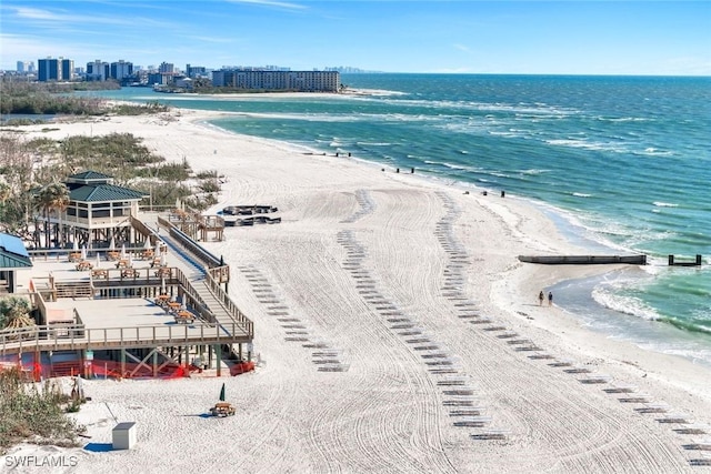 drone / aerial view featuring a water view, a view of city, and a beach view