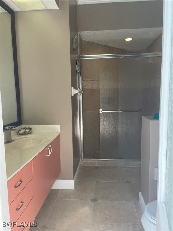 bathroom with toilet, a stall shower, tile patterned flooring, and vanity