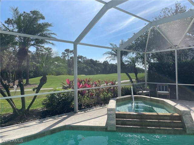 outdoor pool featuring glass enclosure, a patio, a lawn, and an in ground hot tub