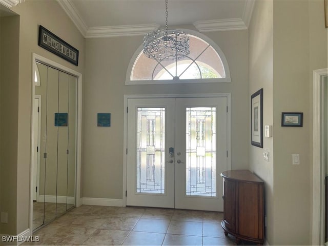 foyer featuring light tile patterned floors, baseboards, crown molding, and french doors