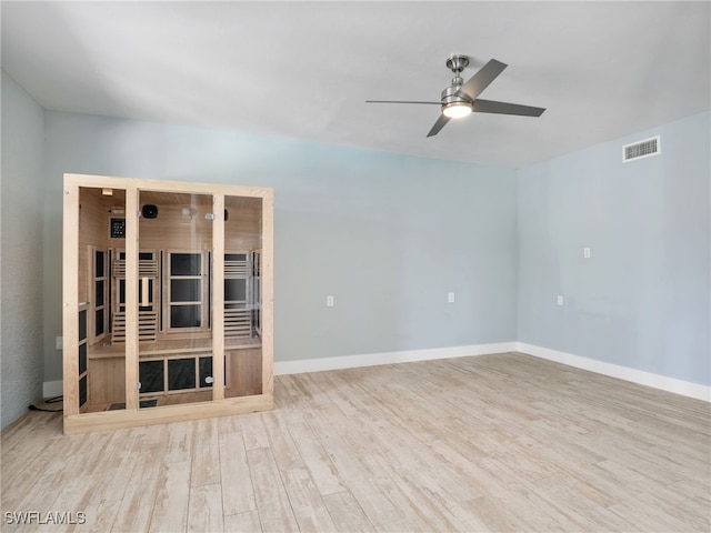 unfurnished living room with light wood finished floors, baseboards, visible vents, and a ceiling fan