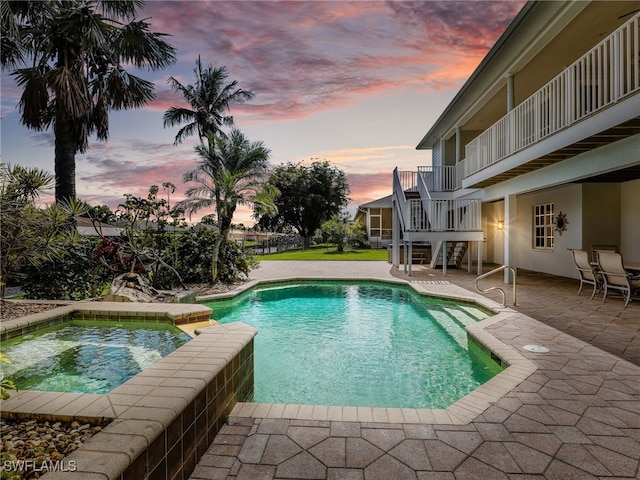 view of pool featuring stairs, a patio area, and a pool with connected hot tub