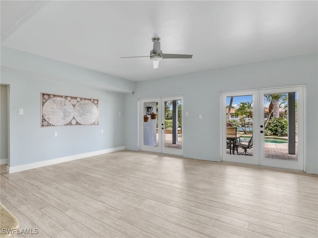 unfurnished living room with light wood-type flooring, a wealth of natural light, and french doors