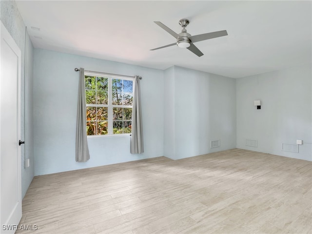 unfurnished room featuring light wood-type flooring, visible vents, and ceiling fan