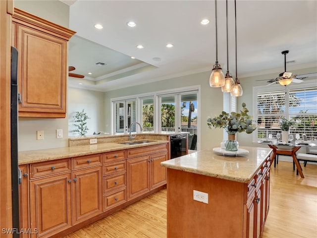 kitchen featuring dishwasher, a kitchen island, a sink, and a ceiling fan