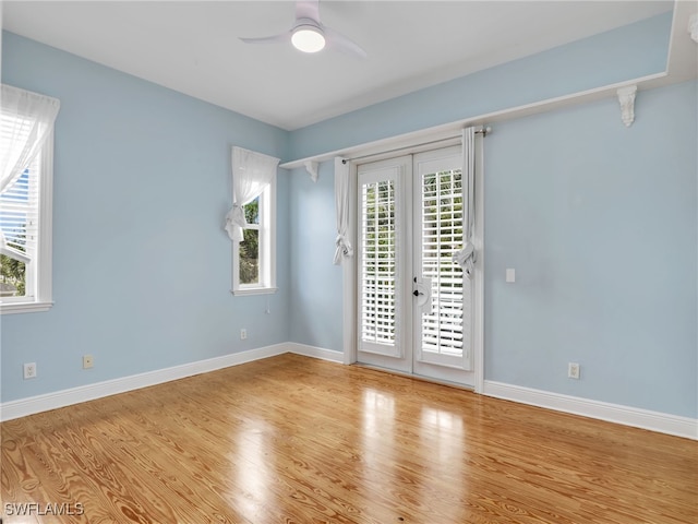 empty room with light wood-style flooring, baseboards, ceiling fan, and french doors