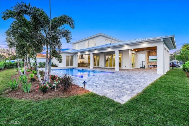 1308 Ridge St, Naples, FL 34103 - back of property with a lawn, an outdoor pool, a patio area, a metal roof, and a standing seam roof