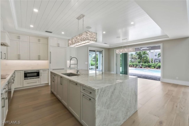 1308 Ridge St, Naples, FL 34103 - kitchen with light wood-style flooring, stainless steel microwave, a sink, a tray ceiling, and wooden ceiling