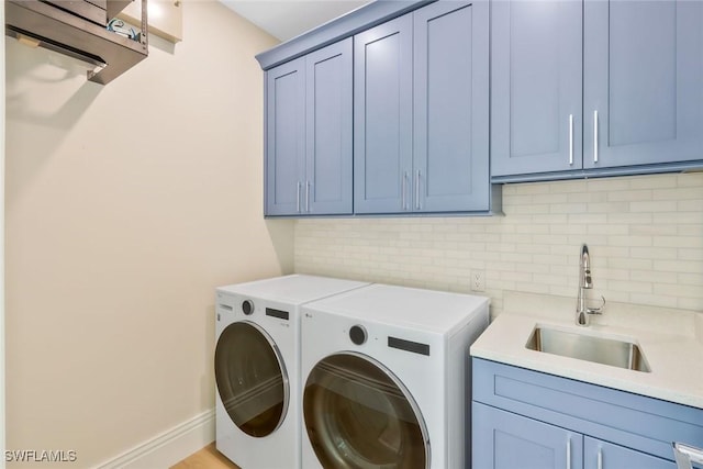 1308 Ridge St, Naples, FL 34103 - clothes washing area with baseboards, washing machine and dryer, cabinet space, and a sink