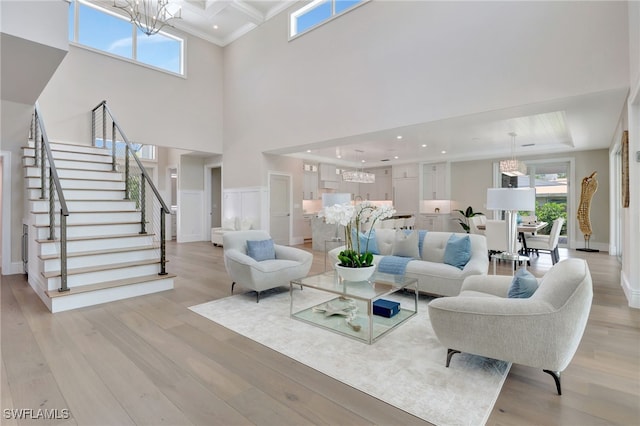 1308 Ridge St, Naples, FL 34103 - living room with a chandelier, stairs, light wood finished floors, crown molding, and a high ceiling
