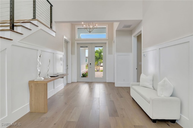1308 Ridge St, Naples, FL 34103 - entryway with a decorative wall, wood finished floors, wainscoting, a chandelier, and french doors