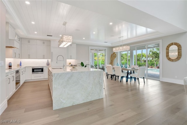 1308 Ridge St, Naples, FL 34103 - kitchen with stainless steel appliances, a center island with sink, recessed lighting, white cabinets, and light wood finished floors