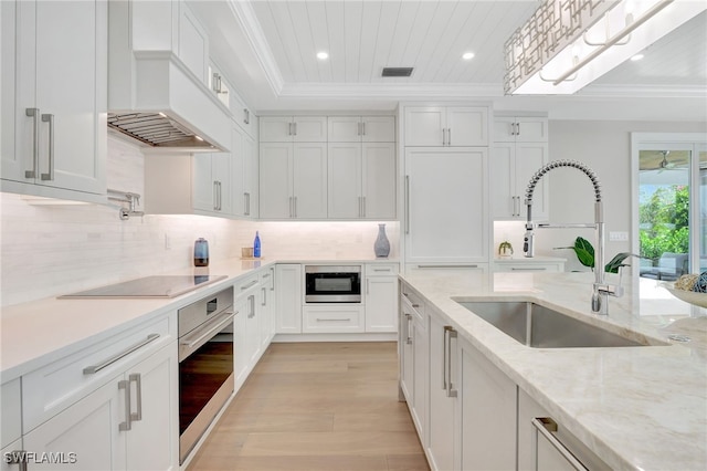 1308 Ridge St, Naples, FL 34103 - kitchen featuring appliances with stainless steel finishes, light wood-style floors, ornamental molding, white cabinets, and recessed lighting