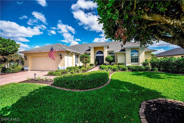 view of front of property with a garage, driveway, a front yard, and stucco siding