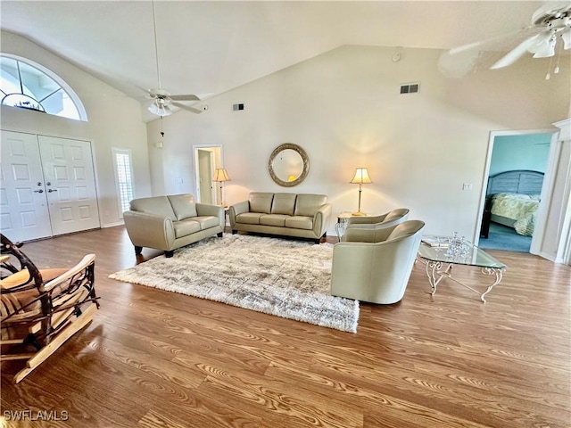 living room with ceiling fan, high vaulted ceiling, wood finished floors, and visible vents