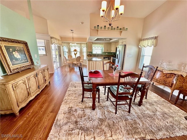 dining area with baseboards, a chandelier, and wood finished floors