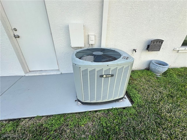 details featuring stucco siding and central AC unit