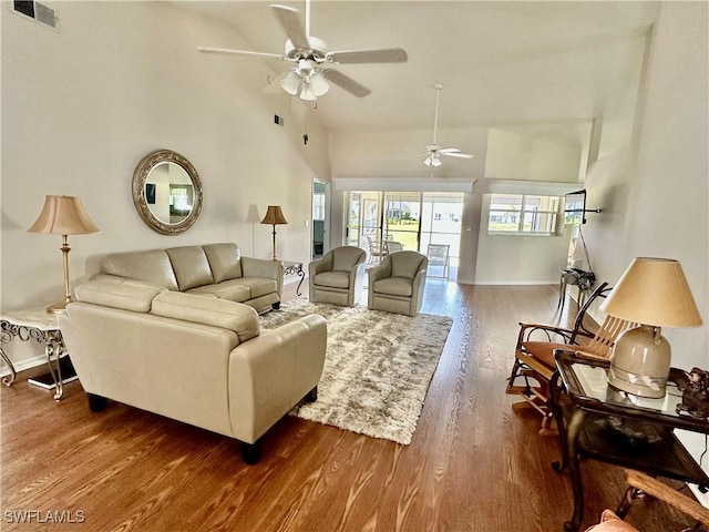 living room featuring baseboards, visible vents, a ceiling fan, wood finished floors, and high vaulted ceiling