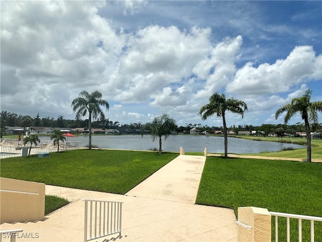 surrounding community featuring a water view, a yard, and fence