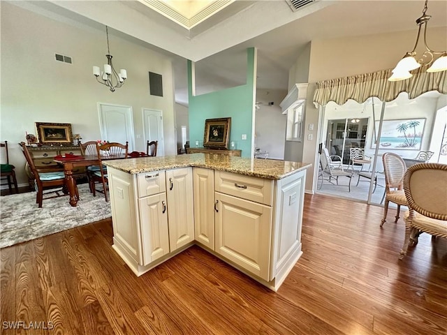 kitchen with dark wood-style floors, visible vents, pendant lighting, and a notable chandelier