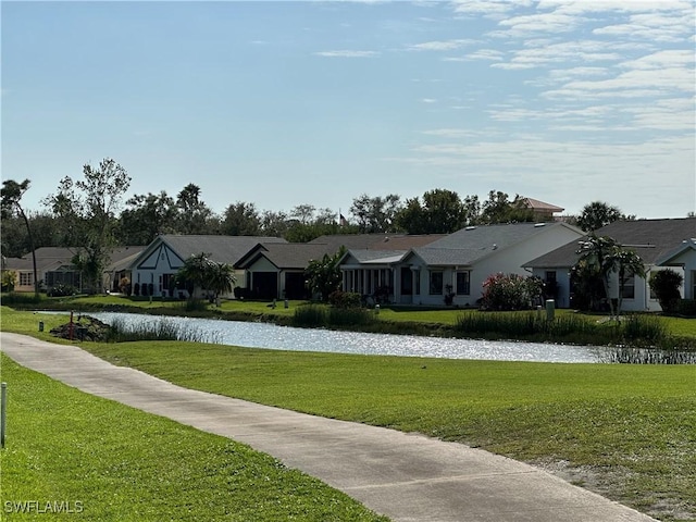 view of front of house featuring a water view, a residential view, and a front yard