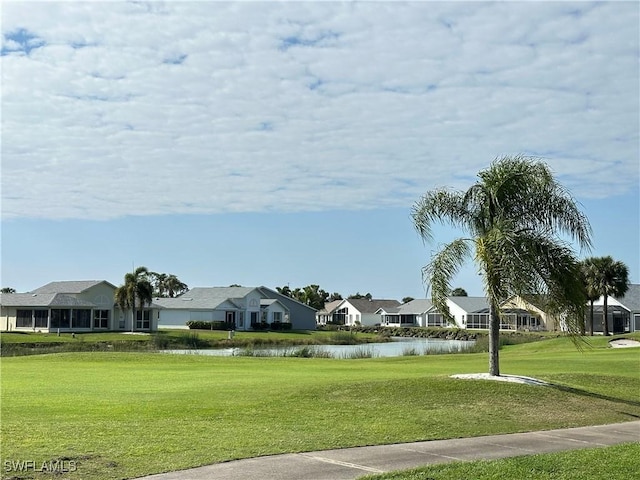 view of home's community with a residential view, a water view, and a lawn