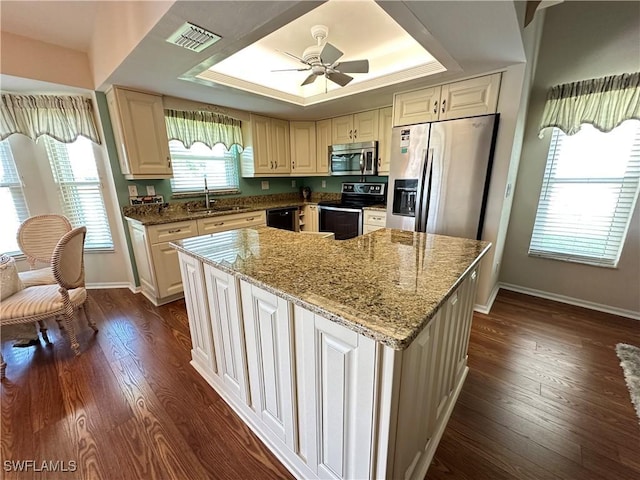 kitchen featuring visible vents, a raised ceiling, appliances with stainless steel finishes, dark wood-style flooring, and a sink