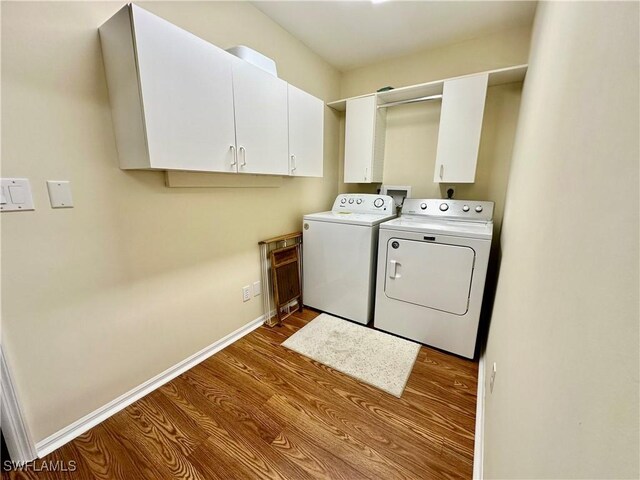 laundry area featuring wood finished floors, cabinet space, baseboards, and separate washer and dryer