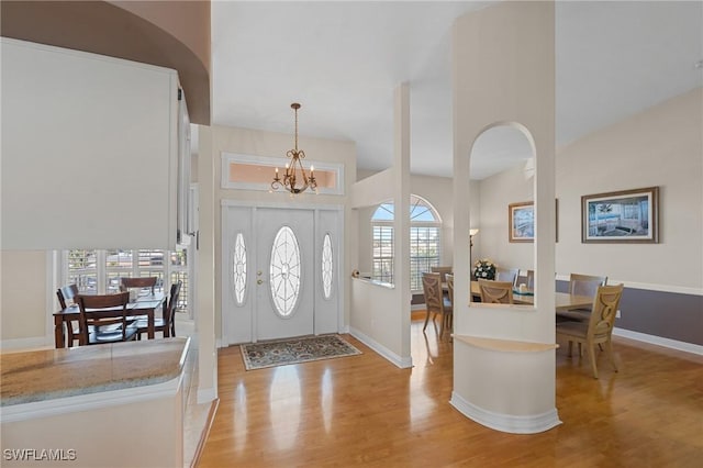 foyer entrance with a healthy amount of sunlight, a chandelier, and light hardwood / wood-style floors