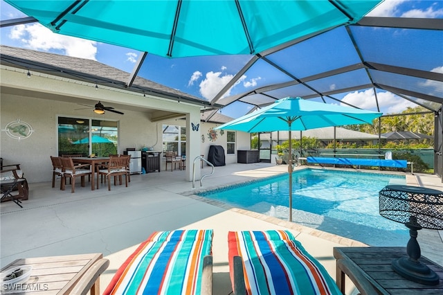 view of pool with a patio, ceiling fan, and glass enclosure