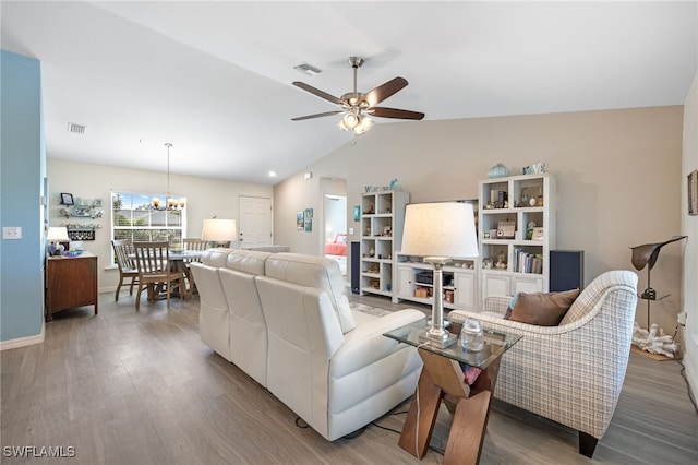 living room featuring hardwood / wood-style flooring, lofted ceiling, and ceiling fan with notable chandelier