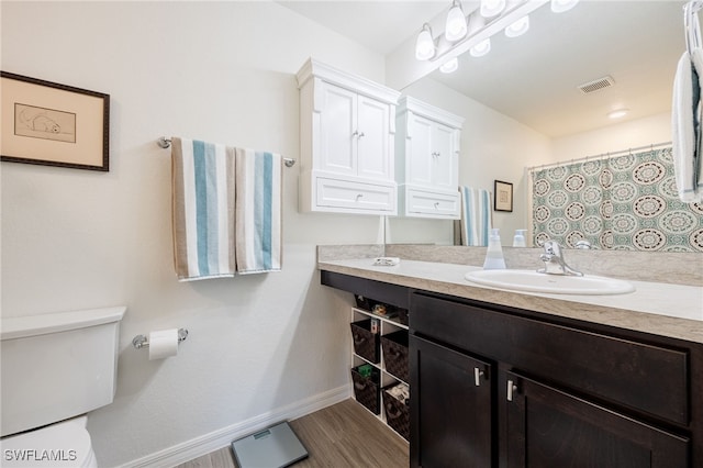 bathroom featuring vanity, hardwood / wood-style floors, and toilet