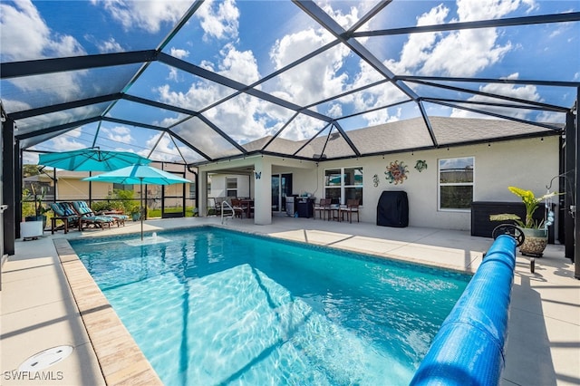 view of swimming pool with pool water feature, a patio area, and glass enclosure