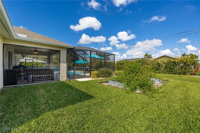 view of yard with ceiling fan and glass enclosure