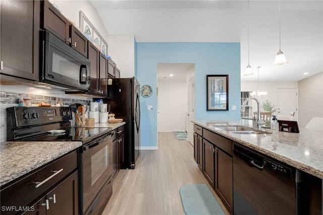 kitchen with sink, hanging light fixtures, dark brown cabinetry, black appliances, and light stone countertops