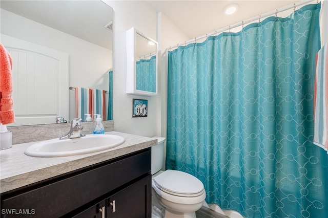 bathroom featuring vanity, a shower with shower curtain, and toilet